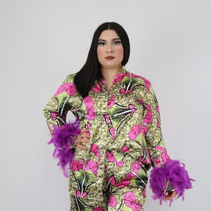 May include: A green and pink patterned satin pyjama set with purple feather trim on the cuffs. The set includes a long-sleeved shirt and matching trousers.
