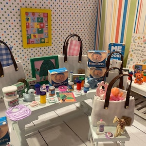 May include: A miniature scene featuring baby products, including Pampers diapers, baby bottles, and a bib. Several tote bags with brown handles are present, along with a framed picture and a sign that reads "I love you more than all the stars in the sky."