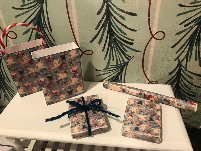 Puede incluir: Un conjunto de suministros para envolver regalos de Navidad con un patr&oacute;n azul y blanco con Pap&aacute; Noel y otros personajes navide&ntilde;os. El conjunto incluye dos bolsas de regalo, un rollo de papel de regalo y una peque&ntilde;a caja de regalo con una cinta azul.
