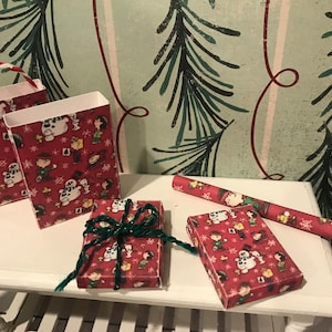 Puede incluir: Dos bolsas de regalo rojas y blancas con un dise&ntilde;o navide&ntilde;o de Peanuts y una caja de regalo roja y blanca con un dise&ntilde;o navide&ntilde;o de Peanuts y un rollo de papel de regalo rojo y blanco con un dise&ntilde;o navide&ntilde;o de Peanuts.