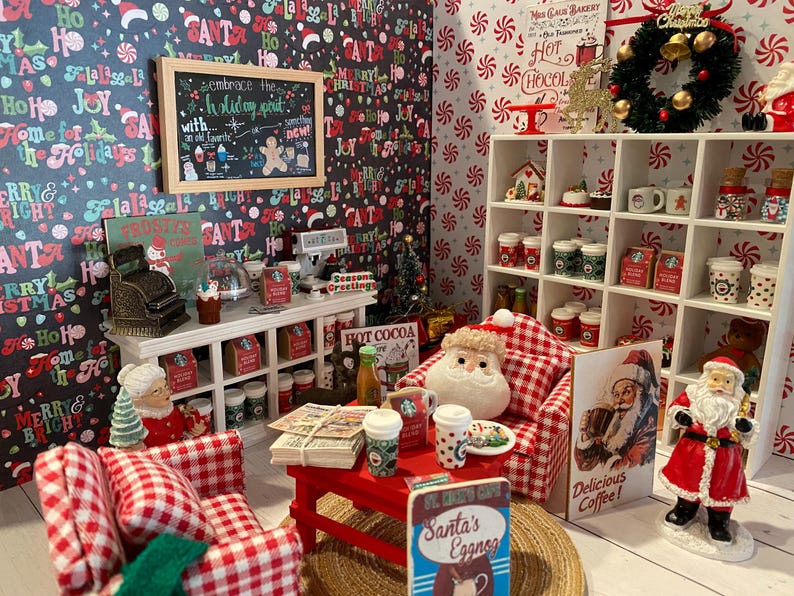 Pode incluir: Uma loja de caf&eacute; em miniatura com tema natalino com m&oacute;veis xadrez vermelhos e brancos, uma placa de giz que diz "embrace the holiday spirit" e uma variedade de bebidas e guloseimas com tema natalino.