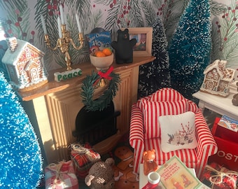 May include: A miniature Christmas scene featuring a fireplace mantel with a gold candelabra, a gingerbread house, a small wreath, a black bear figurine, and a bowl of oranges. A red and white striped armchair with a decorative pillow sits nearby.