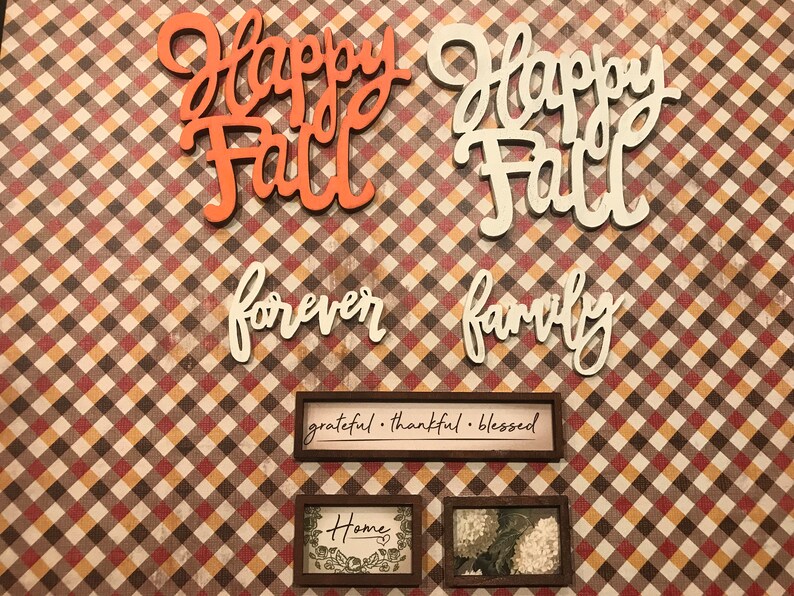 May include: A fall-themed craft project with the words "Happy Fall" in orange and white, "forever family" in white, and three framed signs that say "grateful. thankful. blessed", "Home", and a floral design.