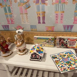 May include: A miniature gingerbread house with colorful candy decorations, two gingerbread people figurines, and two vintage board games: "Candy Land" and "Crazy Land Game".