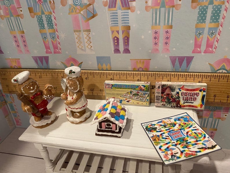 May include: A miniature gingerbread house with colorful candy decorations, two gingerbread people figurines, and two vintage board games: "Candy Land" and "Crazy Land Game".