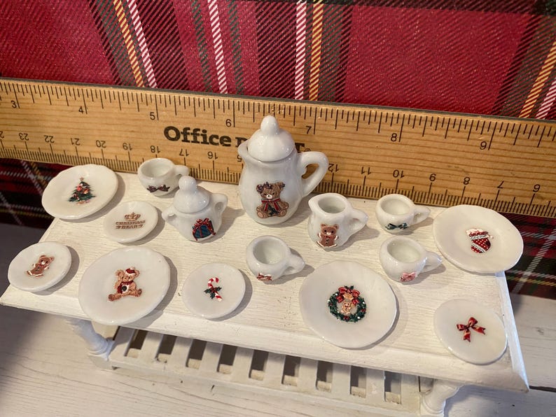 Puede incluir: Juego de t&eacute; navide&ntilde;o en miniatura con acabado blanco. El juego incluye una tetera, una jarra de crema, un azucarero, tazas y platillos. Cada pieza est&aacute; decorada con dise&ntilde;os festivos navide&ntilde;os, incluyendo osos de peluche, &aacute;rboles de Navidad y coronas.