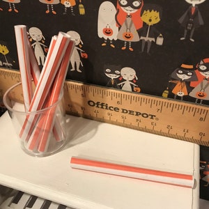 Puede incluir: Un tarro de vidrio lleno de pajitas rayadas rojas y blancas. Una sola pajita rayada roja y blanca est&aacute; sobre una superficie blanca. La superficie est&aacute; junto a una regla de madera con la etiqueta "Office DEPOT".