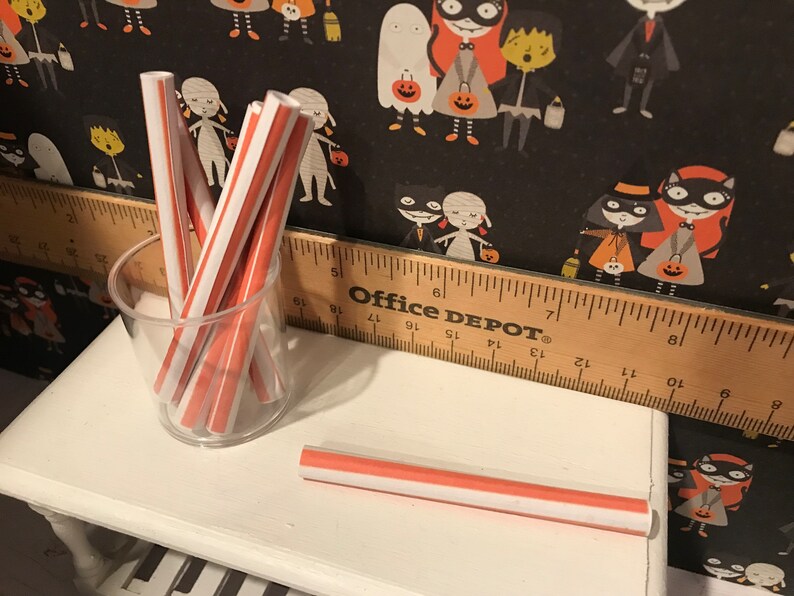 Puede incluir: Un tarro de vidrio lleno de pajitas rayadas rojas y blancas. Una sola pajita rayada roja y blanca est&aacute; sobre una superficie blanca. La superficie est&aacute; junto a una regla de madera con la etiqueta "Office DEPOT".