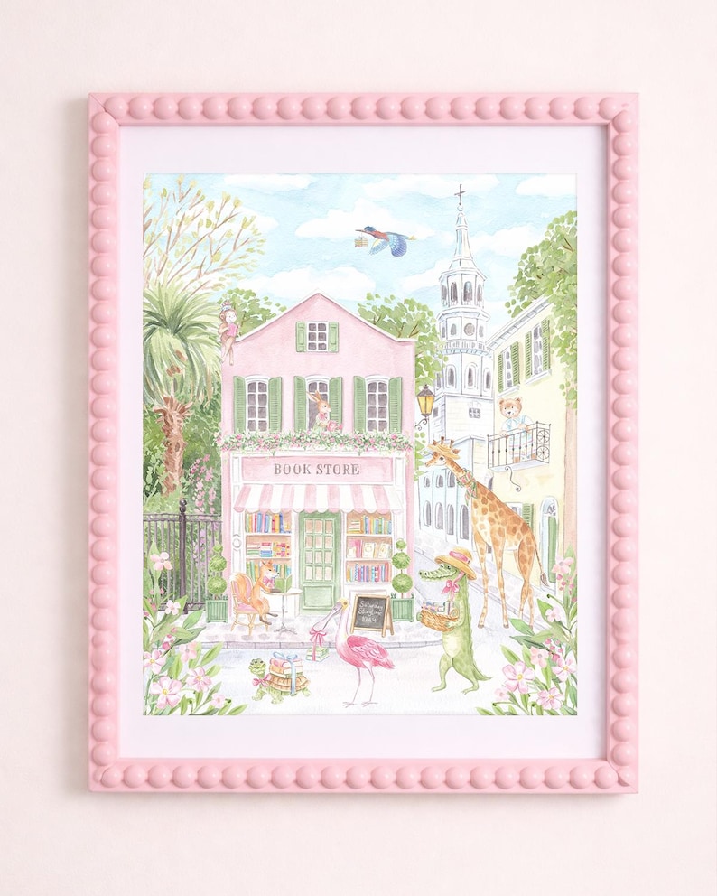 K&ouml;nnte beinhalten: Ein gerahmter Aquarelldruck einer skurrilen Buchladen-Szene. Das rosa Geb&auml;ude hat eine gestreifte Markise und die Worte "BOOK STORE". Eine Giraffe, ein Alligator und ein Flamingo geh&ouml;ren zu den Figuren. Der rosa Rahmen hat einen Perlenrand.