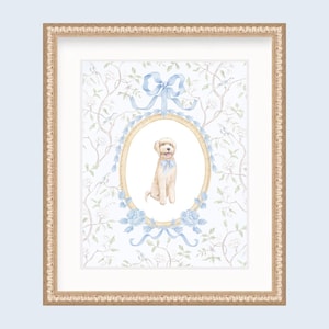 May include: Framed watercolor print featuring a seated cream-colored dog with a blue bow, set within an oval frame adorned with blue ribbons and roses. The background has a floral pattern, and the frame is gold.