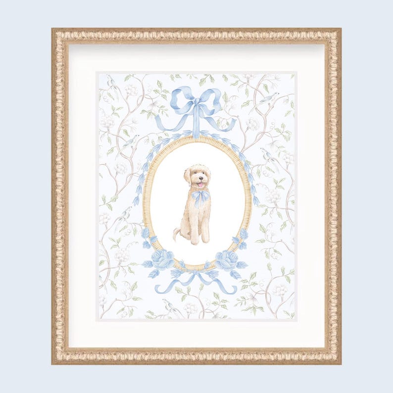 May include: Framed watercolor print featuring a seated cream-colored dog with a blue bow, set within an oval frame adorned with blue ribbons and roses. The background has a floral pattern, and the frame is gold.