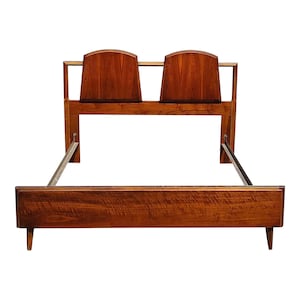 May include: A wooden bed frame with a headboard featuring two curved panels. The frame has a dark brown finish and a metal slat support system.