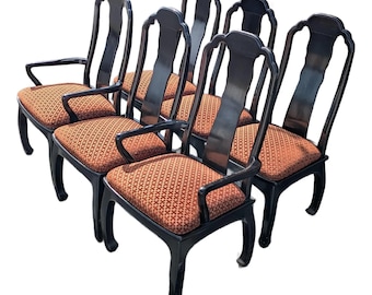 May include: Set of six black dining chairs with curved backs and armrests. The seats are upholstered in a patterned orange fabric. The chairs have a classic, elegant design, suitable for a dining room or kitchen.