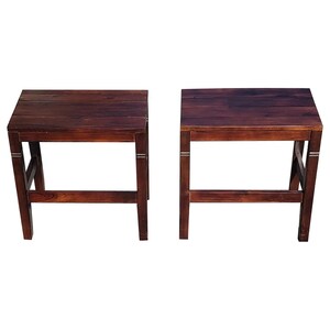May include: Two dark brown wooden stools with a simple design. Each stool has a rectangular top and four legs.