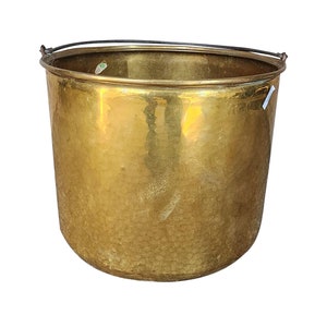 May include: A large, gold-colored brass bucket with a hammered texture and a black metal handle.