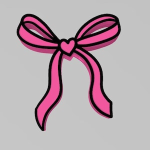 May include: A pink bow with a heart in the center. The bow is outlined in black.