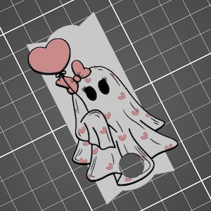 May include: A white ghost with pink hearts printed on its sheet, holding a pink heart-shaped balloon with a pink bow. The ghost has black eyes and a pink bow on its head.