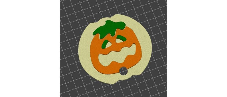 May include: A Halloween-themed pumpkin-shaped ornament. The ornament features an orange pumpkin with a carved face and green stem, set against a light tan background. A small hole is present at the bottom for hanging.