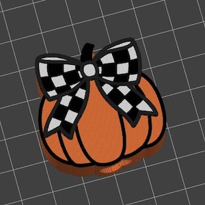 May include: Orange pumpkin with a black and white checkered bow.