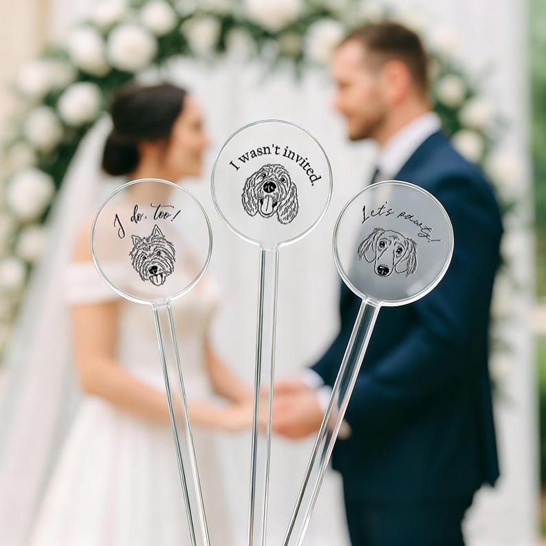 May include: Three clear acrylic wedding signs with dog illustrations and text. One says "I do, too!" with a terrier, another says "I wasn't invited." with a poodle, and the last says "Let's pawty!" with a dachshund.