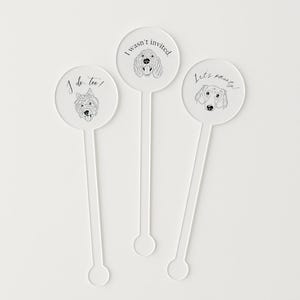 May include: Three clear acrylic drink stirrers with dog illustrations. One stirrer says "I do, too!" with a terrier, another says "I wasn't invited." with a poodle, and the last says "Let's pawty!" with a dachshund.