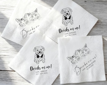 May include: Four white paper napkins featuring black line art illustrations. Two napkins show a dog with a bowtie and the text Drinks on me! Love, Shadow 10 18 2026. Two napkins show two cats and the text Drinks on us! Love, Ian and Oliver 10.19.2026.