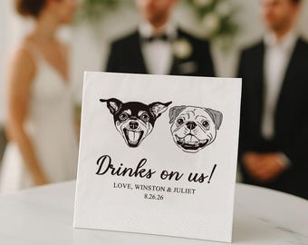 May include: White paper napkin with black illustrations of a Chihuahua and a Pug. The text "Drinks on us!" is written in cursive, with the names "Love, Winston & Juliet" and the date "8.26.26" below.