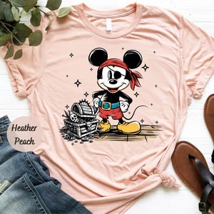 a pink shirt with a mickey mouse on it