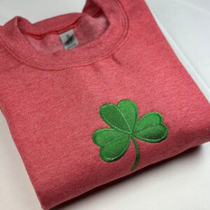 a red shirt with a green clover on it