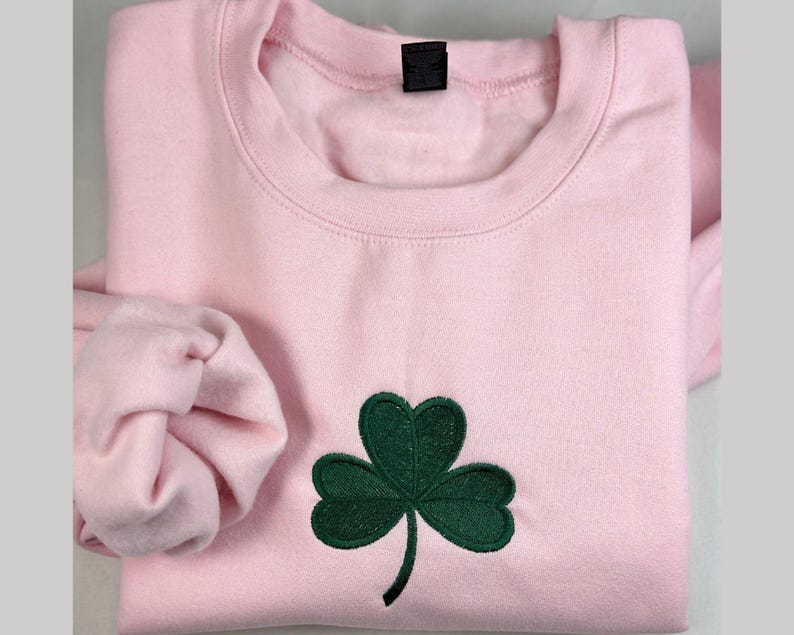 a pink shirt with a green shamrock on it