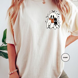 a woman wearing a white t - shirt with a picture of two cats on it