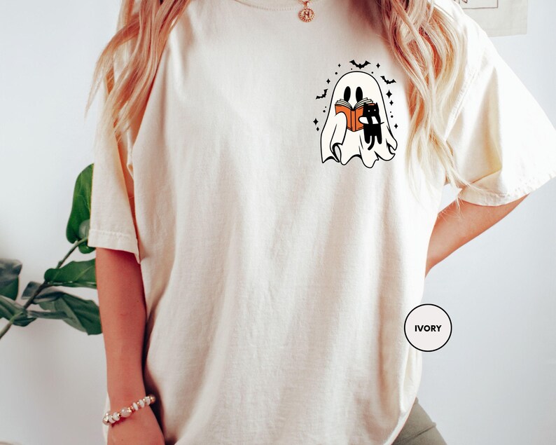 a woman wearing a white t - shirt with a picture of two cats on it