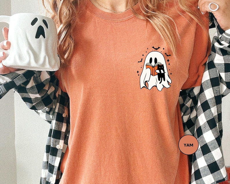 a woman holding a coffee mug with a ghost on it
