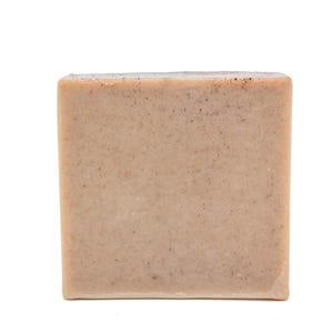May include: A square bar of soap with a light brown color and a grainy texture.