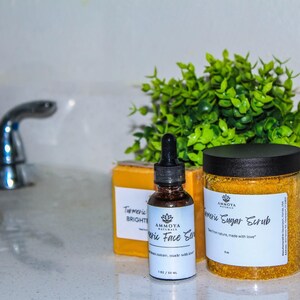 K&ouml;nnte beinhalten: Drei gelbe und wei&szlig;e Flaschen mit Etiketten f&uuml;r Kurkuma-Hautpflegeprodukte. Die Flaschen stehen auf einer wei&szlig;en Arbeitsplatte mit einem wei&szlig;en Waschbecken und einem silbernen Wasserhahn im Hintergrund. Die Flaschen sind mit "Kurkuma-Aufhellendes Gesichtsserum", "Kurkuma-Zuckerpeeling" und "Kurkuma-Aufhellendes Gesichtsserum" beschriftet.