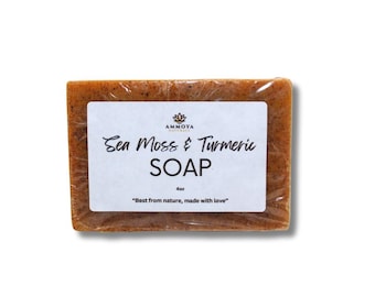 Op de afbeelding: Een bruine zeep met een wit label waarop staat "AMMOYA Naturals Sea Moss & Turmeric SOAP 4oz "Best from nature, made with love""