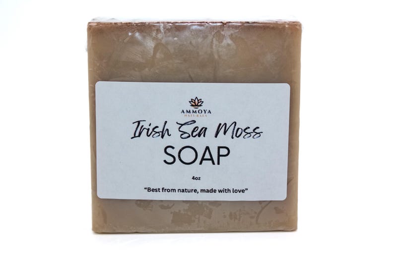 May include: A bar of brown soap with a white label that reads "AMMOYA NATURALS Irish Sea Moss SOAP 4oz "Best from nature, made with love""