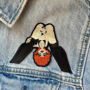 Könnte beinhalten: Ein gestickter Bügel-Patch mit einer Frau in einem weißen Body mit schwarzen Leggings, ihre Haare sind rot und sie steht auf dem Kopf.