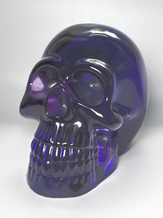 A translucent purple resin skull that looks like it belongs in a Victorian curiosity cabinet — moody, sculptural, and surprisingly versatile as shelf decor.
