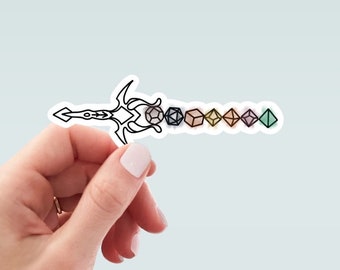 May include: A sticker depicting a sword design in black and white, with a series of colourful dice along the blade. The dice are in various shapes and colours, including grey, black, beige, yellow, pink, purple, and green. The sticker is held by a hand.