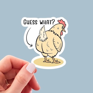 May include: A white chicken with a red comb and wattle is facing away from the viewer. The chicken has a white tail feather and is standing on a yellow surface. The text "GUESS WHAT?" is above the chicken.