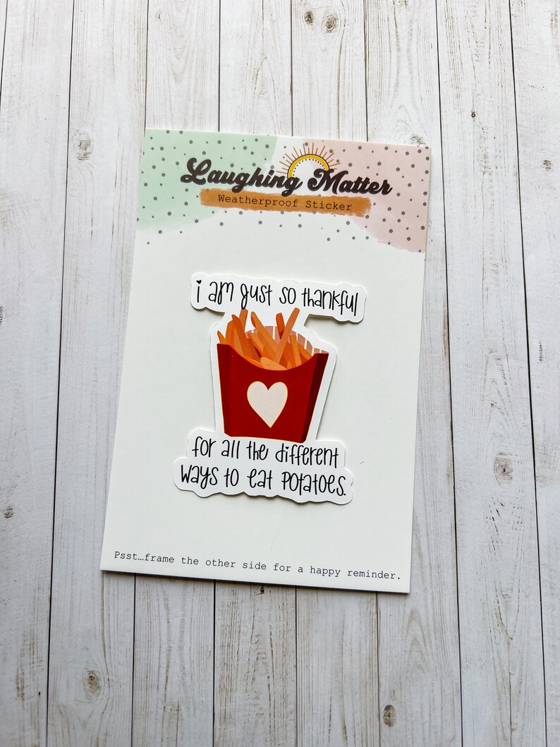 May include: A white sticker with a red and white illustration of a container of french fries. The text on the sticker reads "I am just so thankful for all the different ways to eat potatoes."  The sticker also has the text "Laughing Matter Weatherproof Sticker" at the top.