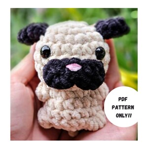 May include: A crocheted plush toy pug with black ears, a black nose, and pink nostrils. The toy is beige and has black eyes. The text "PDF PATTERN ONLY!!" is visible in the image.