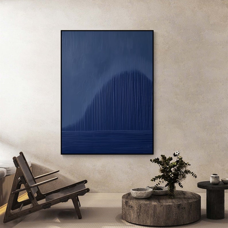 May include: Abstract art print with a dark blue background and vertical lines creating a wave-like pattern. The print is framed in a black frame.