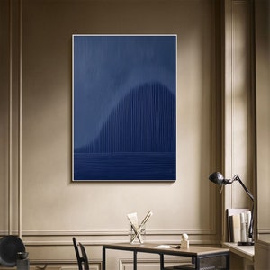 May include: Abstract art print with a dark blue background and a vertical pattern of lines creating a wave-like shape. The print is framed and hanging on a wall.