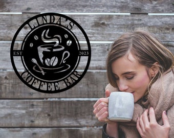 Może przedstawiać: Czarny metalowy znak z tekstem "Linda's Coffee Bar Est 2023" i stylizowanym obrazem filiżanki kawy z unoszącą się parą.