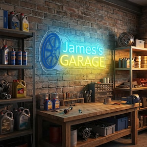 Op de afbeelding: Een garage-interieur met een neonbord met de tekst "James's GARAGE" in blauw en geel, samen met een blauw wielontwerp. De planken zijn gevuld met oliekannen en gereedschap. Een houten werkbank staat in het midden.
