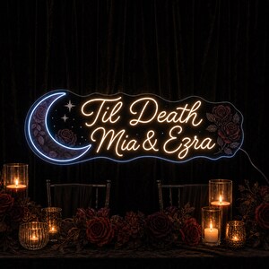 May include: A custom neon sign featuring a crescent moon on the left and roses on the right. The sign displays the text 'Til Death' above 'Mia & Ezra' in a glowing script font. The design includes small star accents and a dark, wavy acrylic backing.
