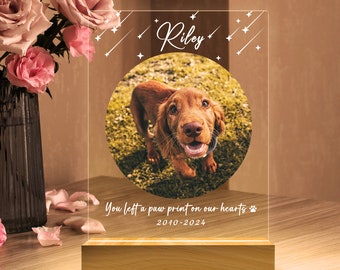 Pode incluir: Uma luz memorial de acrílico personalizada com uma foto de um cão castanho, o nome "Riley" e o texto "You left a paw print on our hearts 2010-2024".