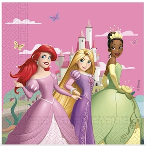 May include: A square paper napkin featuring three animated princesses against a pink castle background. The left figure has long red hair and a pink gown, the center figure has long blonde hair and a purple dress, and the right figure wears a green gown.